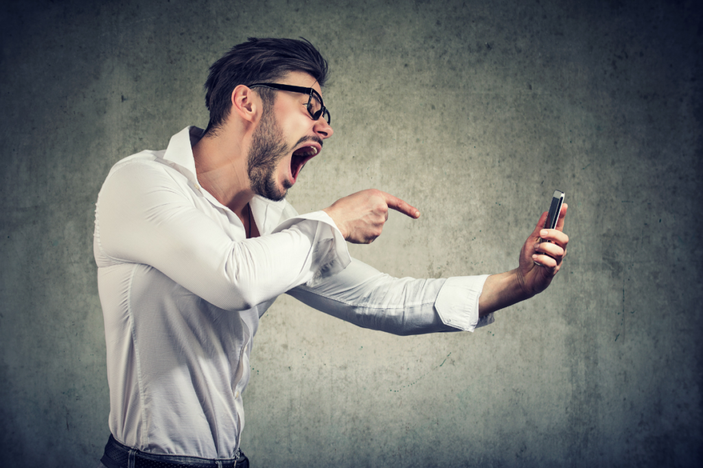 Man yelling into a mobile phone - verbal assault.